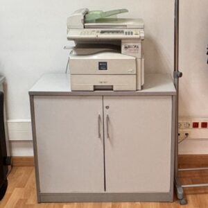 Armario bajo de melamina gris, con puertas y cerradura. 1 balda.